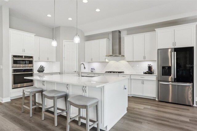 5477 Wayfarer Ave, Apollo Beach, FL 33572 - kitchen featuring stainless steel appliances, wall chimney exhaust hood, a sink, decorative backsplash, and recessed lighting