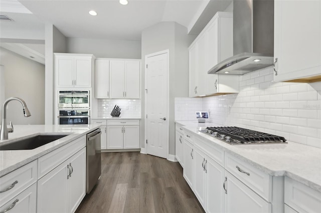 5477 Wayfarer Ave, Apollo Beach, FL 33572 - kitchen featuring wall chimney range hood, a sink, appliances with stainless steel finishes, white cabinets, and recessed lighting