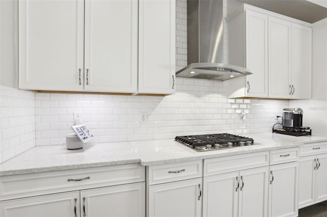 5477 Wayfarer Ave, Apollo Beach, FL 33572 - kitchen with wall chimney range hood, stainless steel gas stovetop, white cabinets, and backsplash