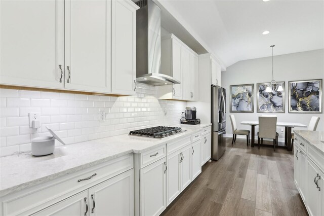 5477 Wayfarer Ave, Apollo Beach, FL 33572 - kitchen featuring stainless steel appliances, wall chimney range hood, white cabinets, wood finished floors, and backsplash