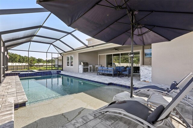 5477 Wayfarer Ave, Apollo Beach, FL 33572 - swimming pool featuring outdoor lounge area, a patio area, an outdoor kitchen, ceiling fan, and glass enclosure