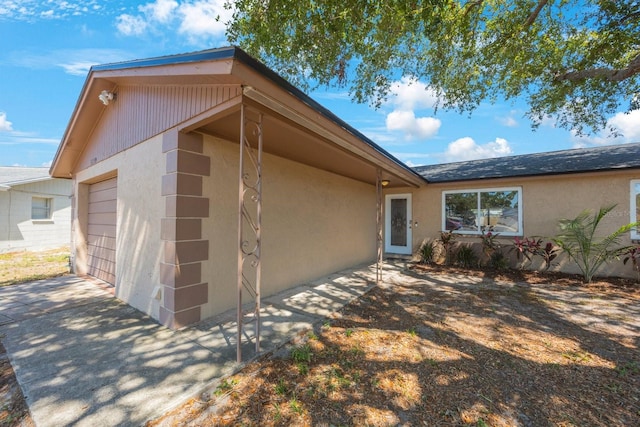 exterior space featuring a garage, stucco siding, and concrete driveway