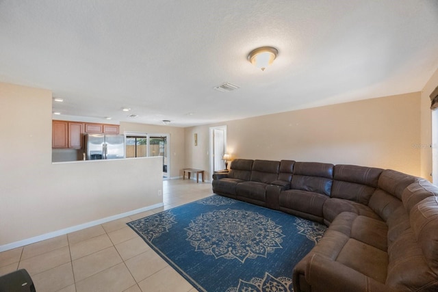 living room with visible vents, baseboards, and light tile patterned floors