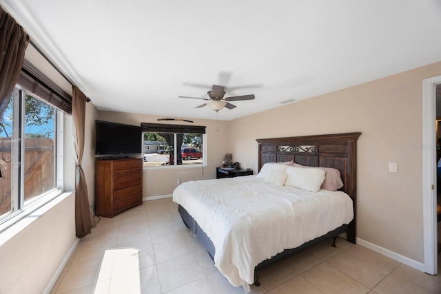 bedroom with light tile patterned flooring, baseboards, multiple windows, and ceiling fan