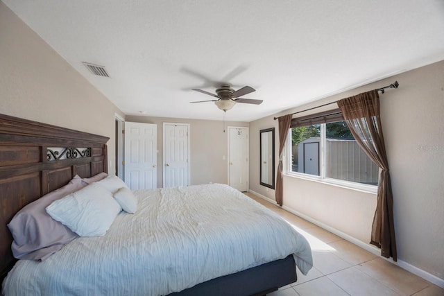 bedroom with baseboards, a ceiling fan, light tile patterned floors, and visible vents