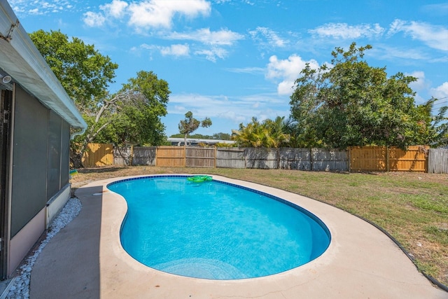 view of swimming pool featuring a lawn, a fenced in pool, and a fenced backyard