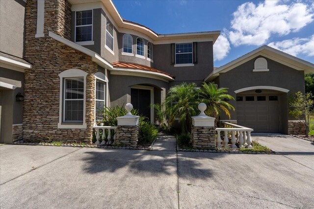 16637 Ashton Green Dr, Lutz, FL 33558 - view of front of property featuring an attached garage, driveway, stone siding, and stucco siding