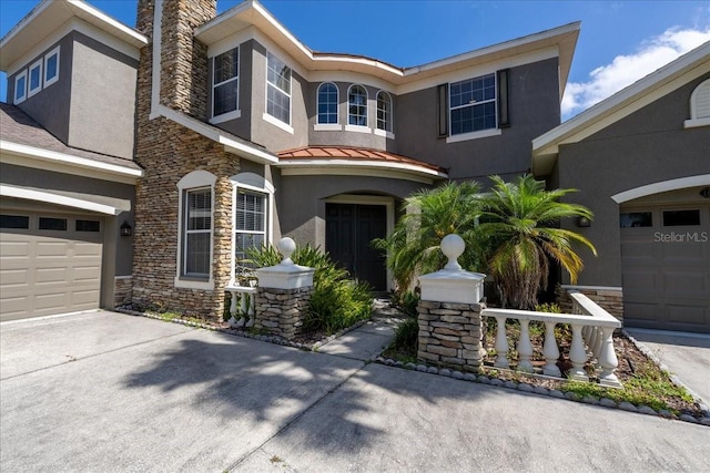 16637 Ashton Green Dr, Lutz, FL 33558 - view of front of house with a garage, stone siding, stucco siding, a standing seam roof, and concrete driveway