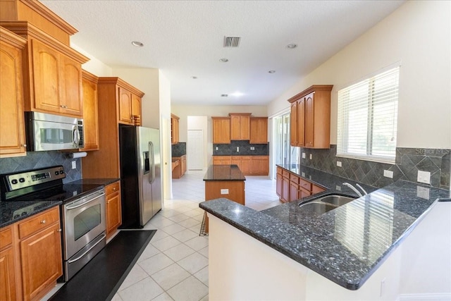 16637 Ashton Green Dr, Lutz, FL 33558 - kitchen with visible vents, tasteful backsplash, a sink, light tile patterned floors, and stainless steel appliances