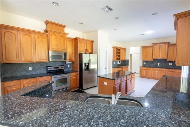 16637 Ashton Green Dr, Lutz, FL 33558 - kitchen featuring appliances with stainless steel finishes, a sink, a center island, decorative backsplash, and visible vents