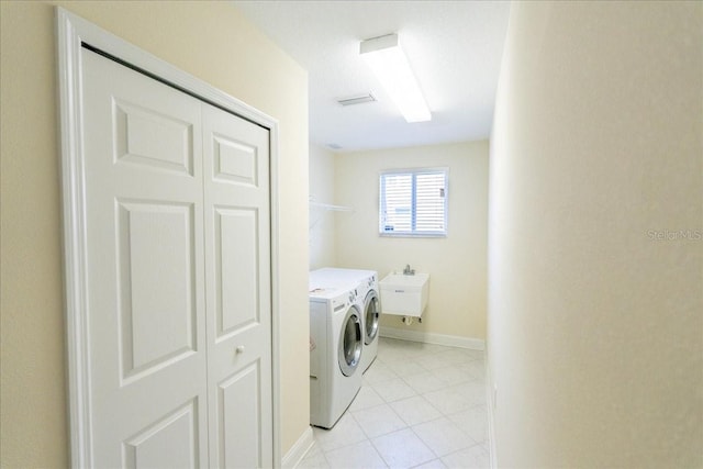 16637 Ashton Green Dr, Lutz, FL 33558 - laundry room with laundry area, visible vents, washing machine and dryer, light tile patterned flooring, and baseboards