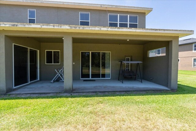 16637 Ashton Green Dr, Lutz, FL 33558 - rear view of property featuring a patio, stucco siding, and a yard