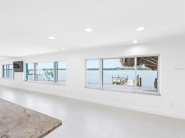 326 176th Avenue Cir, Redington Shores, FL 33708 - unfurnished living room with tile patterned floors, recessed lighting, baseboards, and a water view