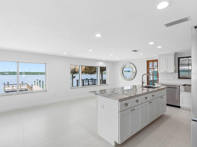 326 176th Avenue Cir, Redington Shores, FL 33708 - kitchen featuring dishwasher, a sink, light stone countertops, white cabinetry, and a kitchen island with sink