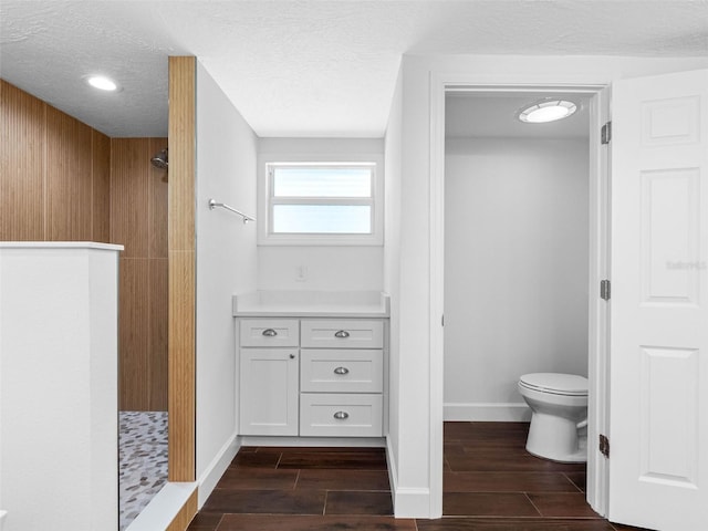 326 176th Avenue Cir, Redington Shores, FL 33708 - full bath with a shower stall, toilet, wood tiled floors, baseboards, and a textured ceiling