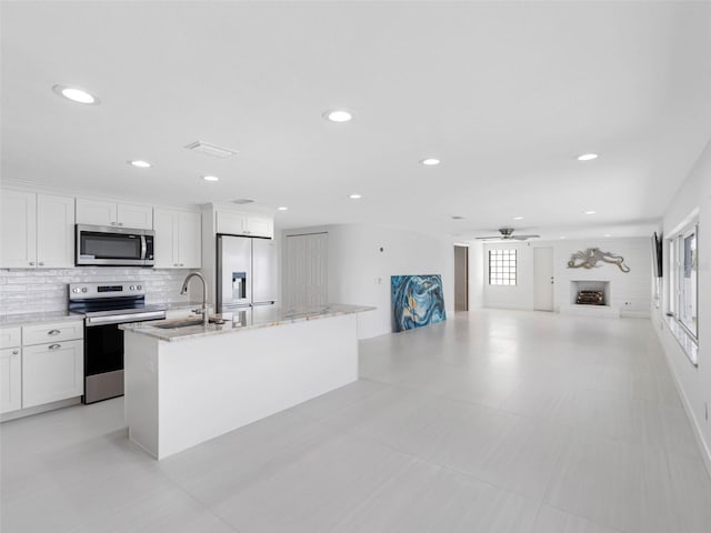 326 176th Avenue Cir, Redington Shores, FL 33708 - kitchen with appliances with stainless steel finishes, a sink, an island with sink, ceiling fan, and white cabinetry