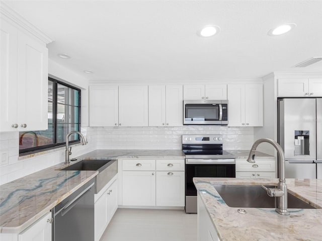 326 176th Avenue Cir, Redington Shores, FL 33708 - kitchen featuring appliances with stainless steel finishes, a sink, white cabinetry, decorative backsplash, and recessed lighting