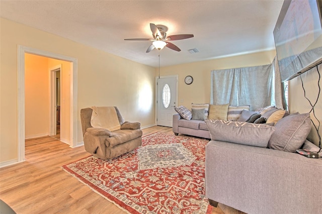 5939 14th St, Zephyrhills, FL 33542 - living room featuring baseboards, ceiling fan, visible vents, and light wood-style flooring