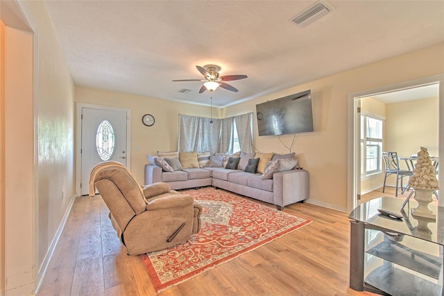 5939 14th St, Zephyrhills, FL 33542 - living room featuring visible vents, light wood finished floors, ceiling fan, and baseboards