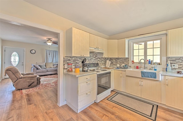 5939 14th St, Zephyrhills, FL 33542 - kitchen featuring white electric stove, a sink, light countertops, light wood finished floors, and under cabinet range hood