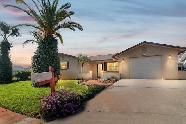 7534 Culberson Dr, Port Richey, FL 34668 - ranch-style house with a lawn, a garage, stucco siding, and driveway