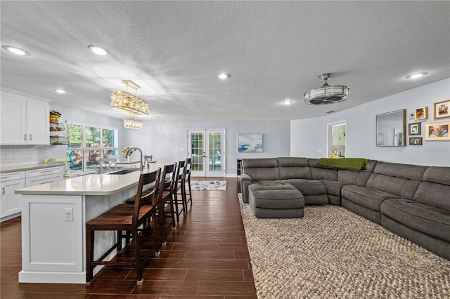 living area featuring recessed lighting, a textured ceiling, a notable chandelier, and wood tiled floor