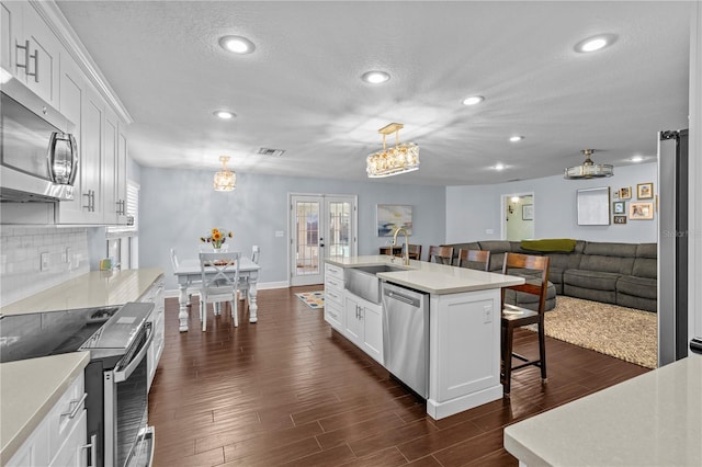 kitchen featuring visible vents, a breakfast bar, recessed lighting, a sink, and appliances with stainless steel finishes