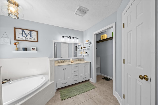 bathroom with double vanity, tile patterned flooring, a sink, and a bath