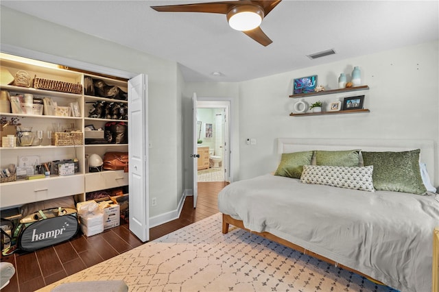 bedroom with a ceiling fan, visible vents, wood finished floors, baseboards, and a closet