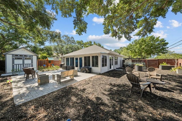 back of house with a storage shed, a patio, an outbuilding, and a fenced backyard