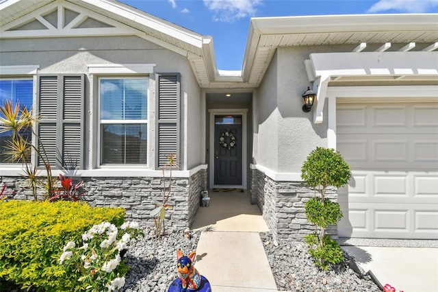 doorway to property featuring stucco siding, an attached garage, and stone siding