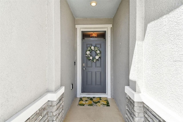 property entrance with stucco siding