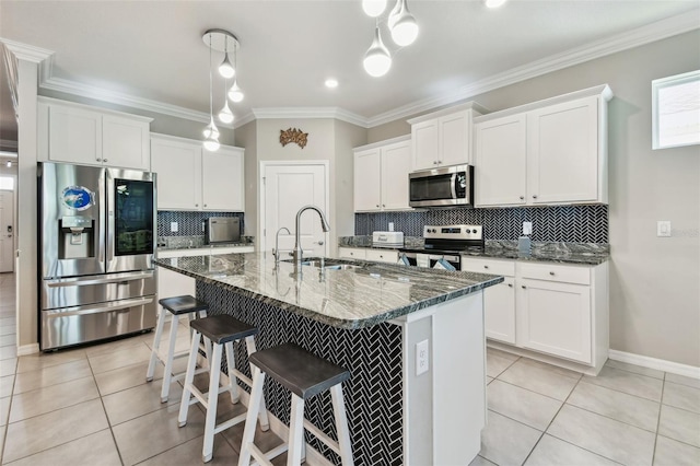 kitchen with white cabinets, stainless steel appliances, light tile patterned floors, and a sink