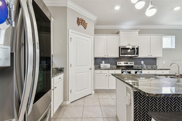 kitchen featuring white cabinets, a sink, stainless steel appliances, tasteful backsplash, and ornamental molding