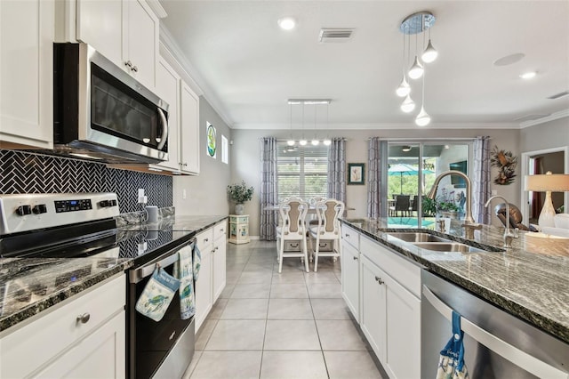 kitchen featuring decorative backsplash, visible vents, crown molding, a sink, and stainless steel appliances