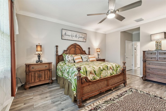bedroom with baseboards, visible vents, ornamental molding, and wood finished floors