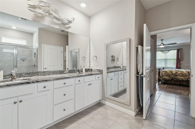 bathroom with double vanity, a stall shower, a sink, tile patterned floors, and connected bathroom