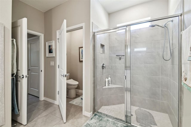 full bath with tile patterned floors, a stall shower, and toilet