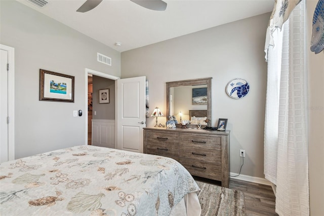 bedroom with baseboards, a ceiling fan, wood finished floors, and visible vents