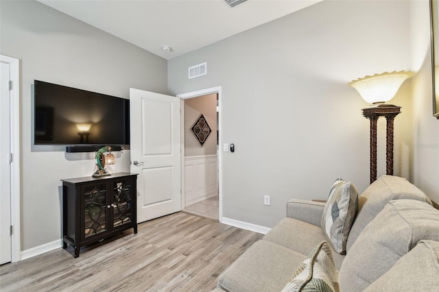 living room with visible vents, baseboards, and light wood-type flooring