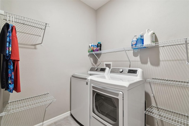 washroom featuring light tile patterned floors, baseboards, laundry area, and independent washer and dryer
