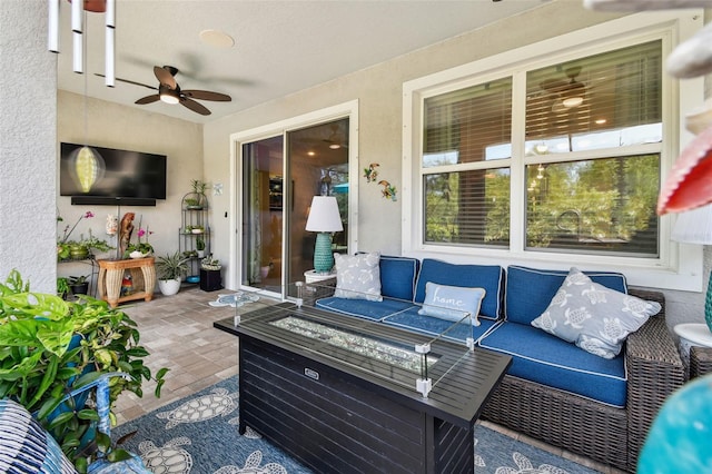 view of patio / terrace featuring ceiling fan and an outdoor living space with a fire pit
