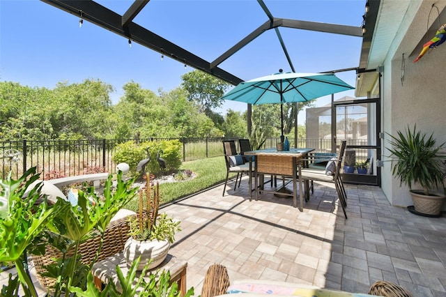 view of patio featuring a fenced backyard, glass enclosure, and outdoor dining space