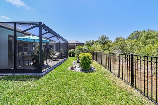view of yard with a patio, a fenced backyard, and a lanai