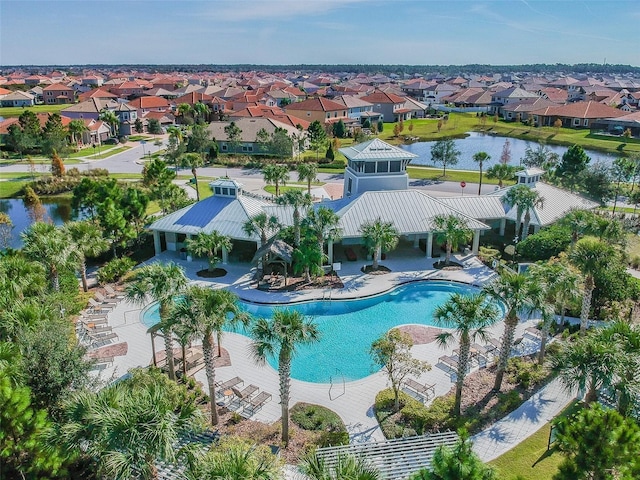 community pool featuring a water view, a residential view, and a patio area