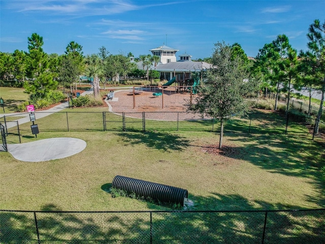 community jungle gym featuring fence and a yard