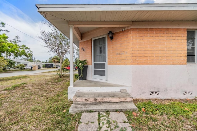 5101 13th Ave S, Gulfport, FL 33707 - doorway to property with stucco siding, a yard, and brick siding