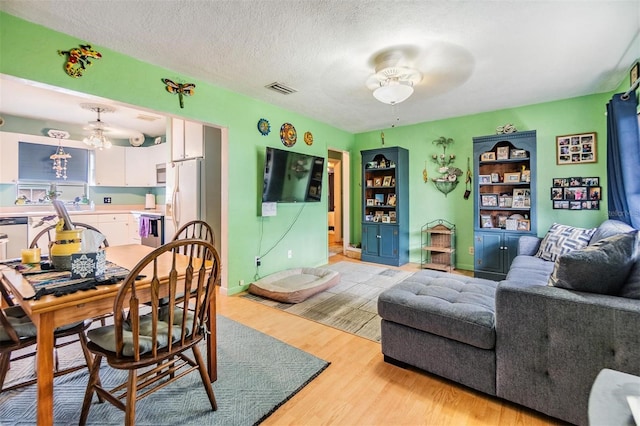 5101 13th Ave S, Gulfport, FL 33707 - living area featuring a ceiling fan, light wood-type flooring, a textured ceiling, and visible vents