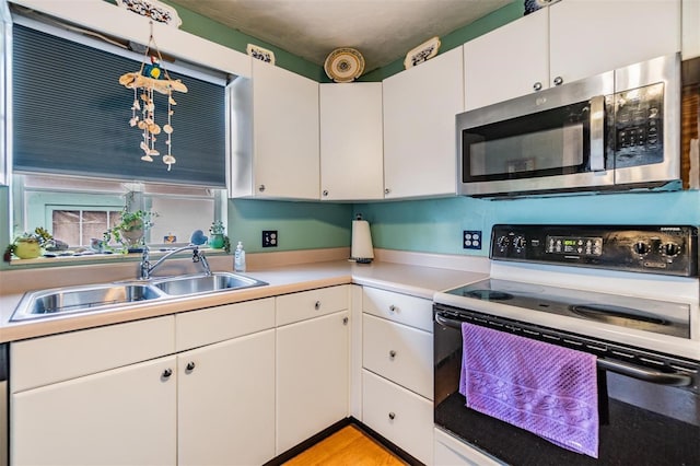 5101 13th Ave S, Gulfport, FL 33707 - kitchen with a sink, electric range oven, stainless steel microwave, and white cabinets