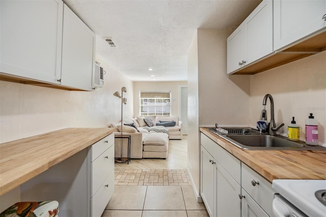 5101 13th Ave S, Gulfport, FL 33707 - kitchen with white cabinetry, wooden counters, and a sink